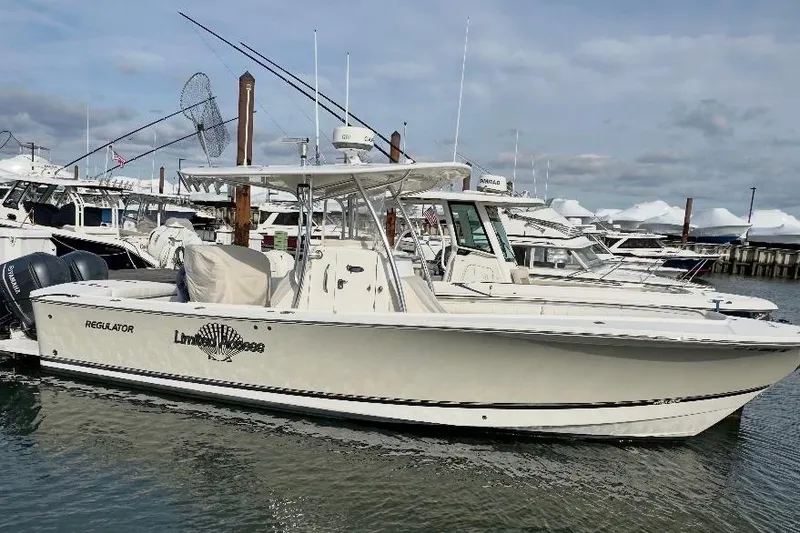 Slide: The Image of 2015 Regulator 28 Forward Seating boat docked in marina, side view. - 3