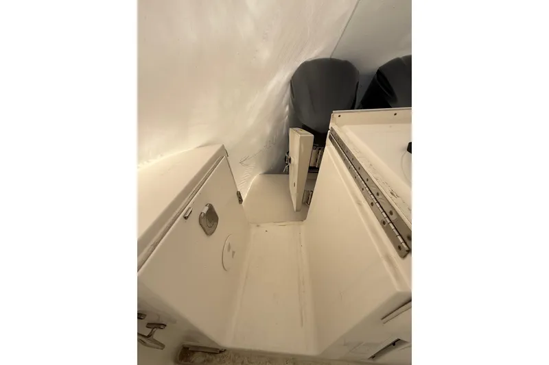 Slide: The Image of 2015 Regulator 28 Forward Seating boat interior with storage compartments and dual engines. - 43