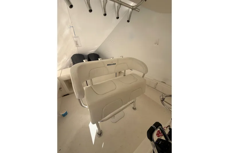 Slide: The Image of 2015 Regulator 28 Forward Seating boat interior with white cushioned seats and rod holders. - 47