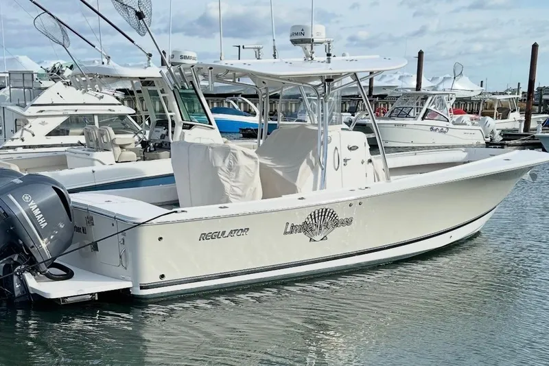 Slide: The Image of 2015 Regulator 28 Forward Seating boat docked in marina with Yamaha engine. - 5