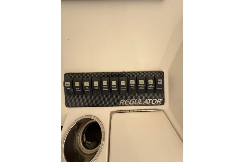 Slide: The Image of Control panel of a 2015 Regulator 28 Forward Seating boat with labeled switches. - 57