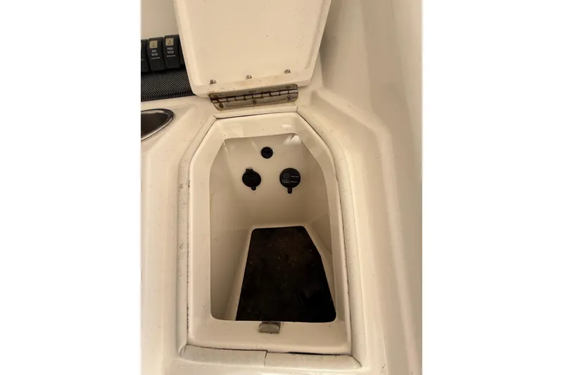 Slide: The Image of 2015 Regulator 28 Forward Seating storage compartment with open hatch and visible controls. - 58