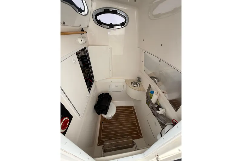 Slide: The Image of 2015 Regulator 28 Forward Seating boat interior with compact bathroom amenities. - 65