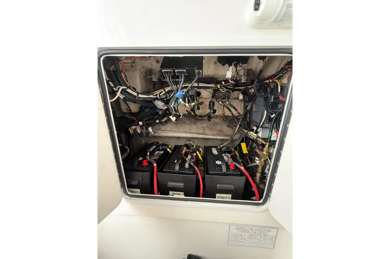 Slide: The Image of Electrical compartment of a 2015 Regulator 28 Forward Seating boat, showing batteries and wiring. - 66