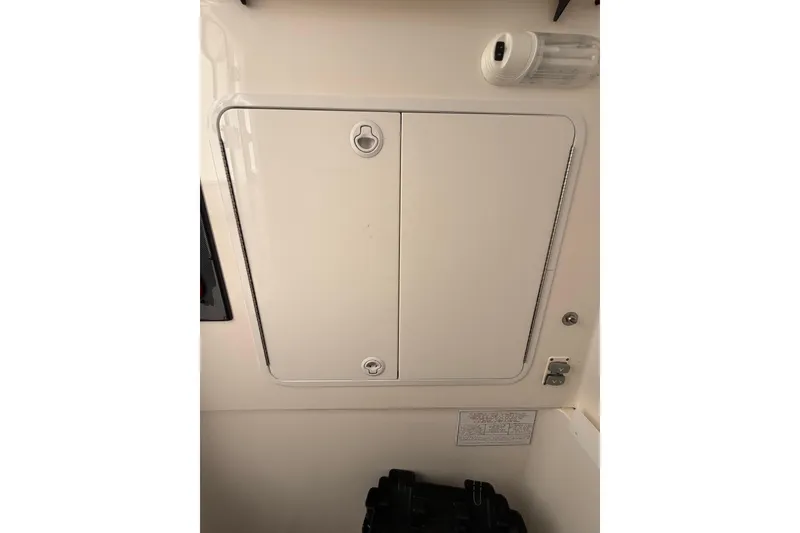 Slide: The Image of 2015 Regulator 28 Forward Seating boat storage compartment with secure latch and clean design. - 68