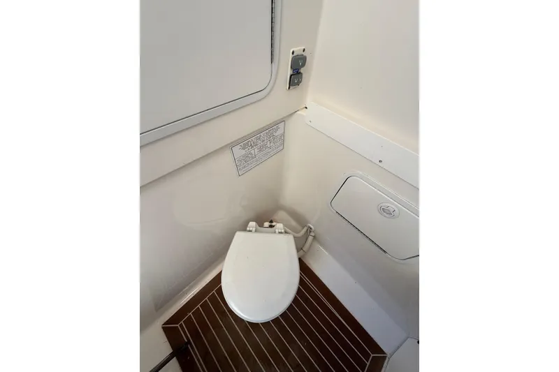 Slide: The Image of 2015 Regulator 28 Forward Seating boat interior with compact marine toilet. - 71