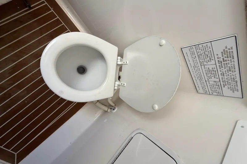 Slide: The Image of 2015 Regulator 28 Forward Seating boat toilet with wooden flooring and instruction panel. - 72