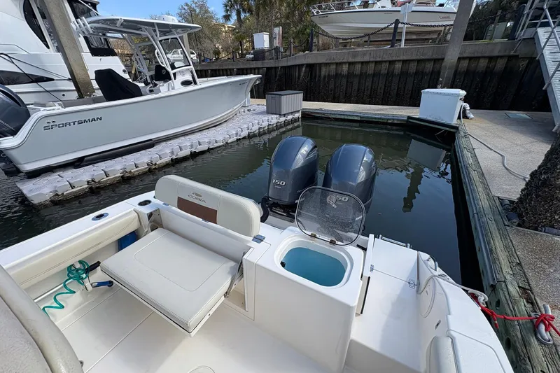 Slide: The Image of 2020 Cobia 240 Center Console boat docked with twin engines, featuring a spacious deck. - 10
