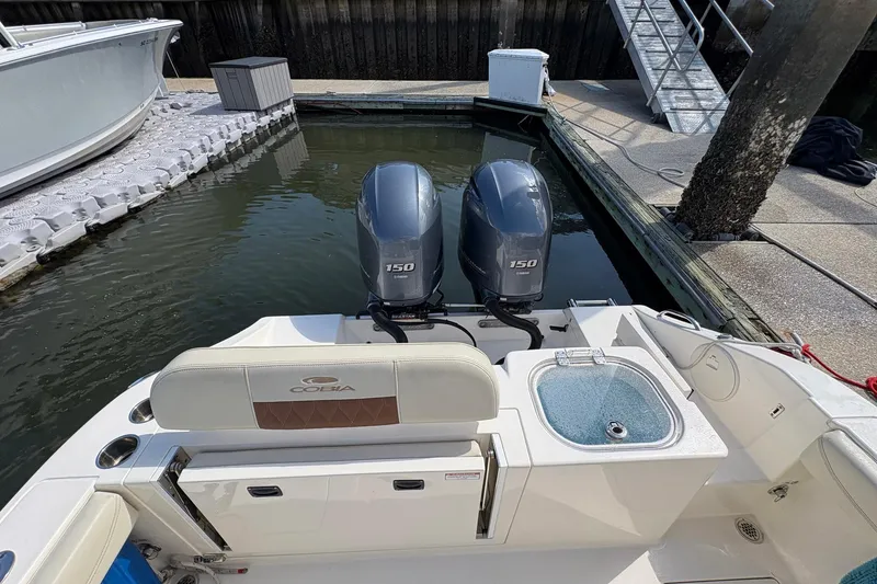 Slide: The Image of 2020 Cobia 240 Center Console boat with twin 150 engines docked at marina. - 12