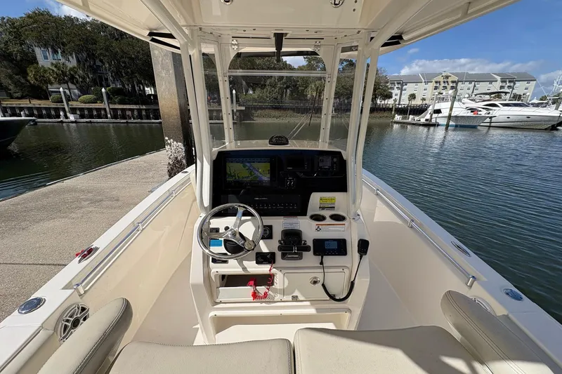Slide: The Image of 2020 Cobia 240 Center Console boat at marina, featuring modern helm and navigation equipment. - 15