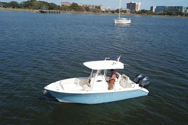 Slide: The Image of 2020 Cobia 240 Center Console boat on calm water with scenic background. - 2