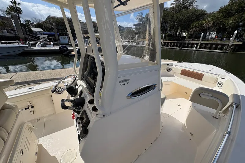 Slide: The Image of 2020 Cobia 240 Center Console boat docked, featuring helm and seating area. - 22