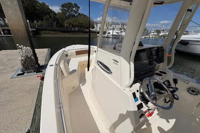 Slide: The Image of 2020 Cobia 240 Center Console boat docked at marina, featuring steering console and seating. - 23