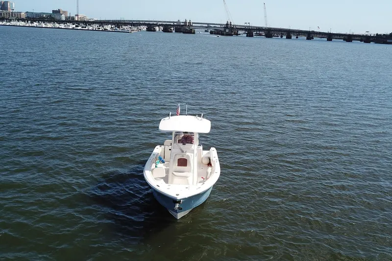 Slide: The Image of 2020 Cobia 240 Center Console boat on calm water near a bridge. - 3