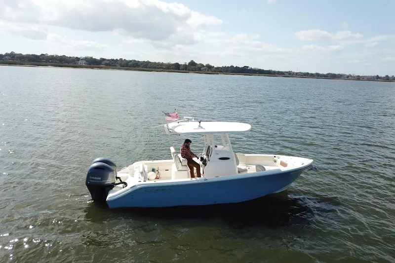 Slide: The Image of 2020 Cobia 240 Center Console boat on calm water, featuring a Yamaha outboard motor. - 5