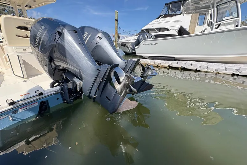Slide: The Image of 2020 Cobia 240 Center Console with twin Yamaha outboard motors docked in marina. - 8