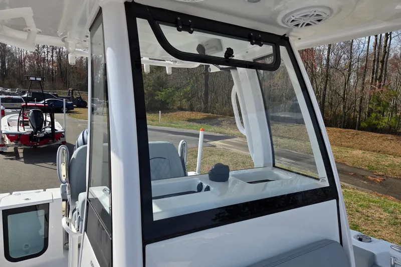 Slide: The Image of 2026 Sportsman Open 212 Center Console boat with clear windshield, parked outdoors. - 10
