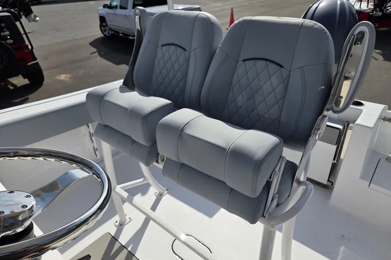 Slide: The Image of 2026 Sportsman Open 212 Center Console boat seats with diamond stitching and steering wheel. - 15