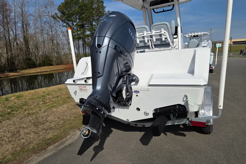 Slide: The Image of 2026 Sportsman Open 212 Center Console boat with Yamaha outboard motor, parked near a pond. - 3