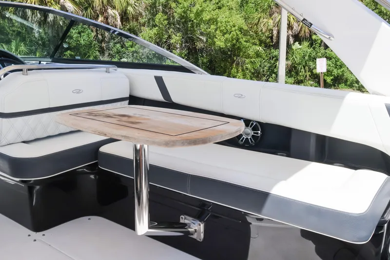 Slide: The Image of 2019 Regal 29 OBX boat interior with white seating and wooden table. - 22
