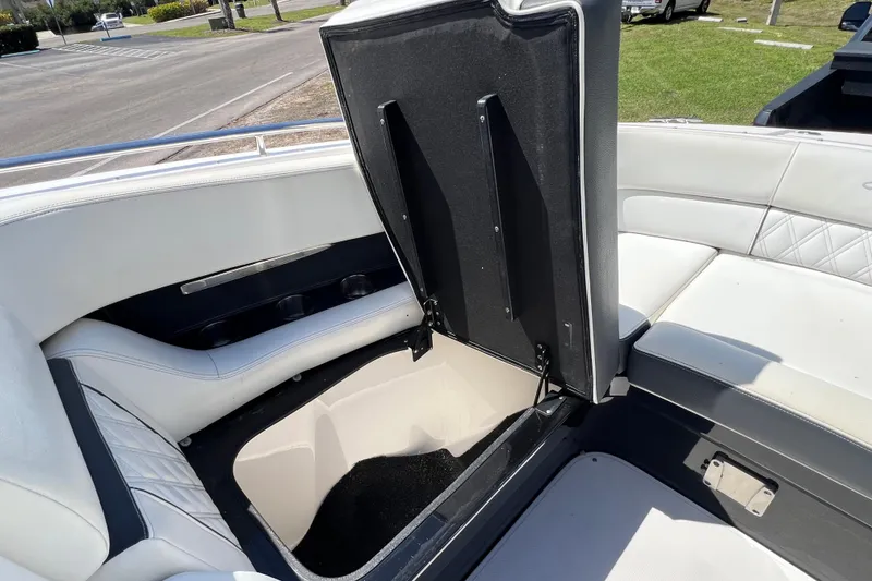 Slide: The Image of 2019 Regal 29 OBX boat interior with open storage compartment and white seating. - 39