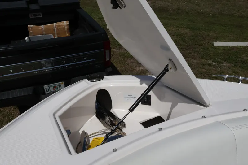 Slide: The Image of Open storage compartment on 2019 Regal 29 OBX boat, with truck in background. - 41
