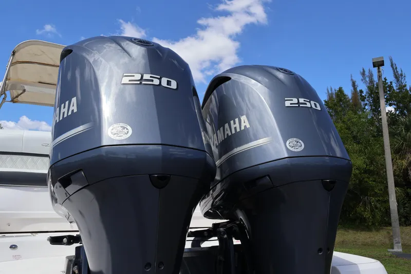 Slide: The Image of Twin Yamaha 250 outboard engines on a 2019 Regal 29 OBX boat under blue sky. - 8