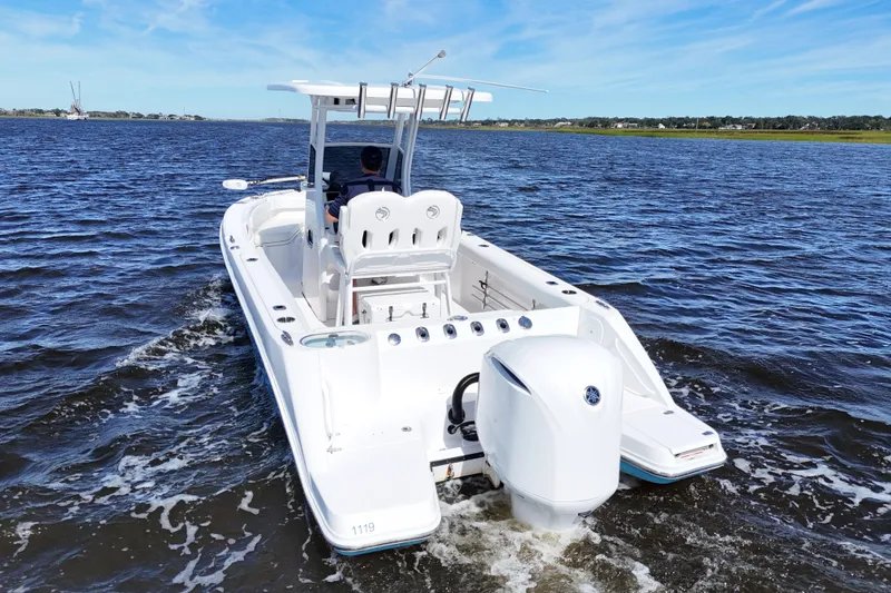 Slide: The Image of 2019 Edgewater 230CC boat cruising on open water under clear blue skies. - 11