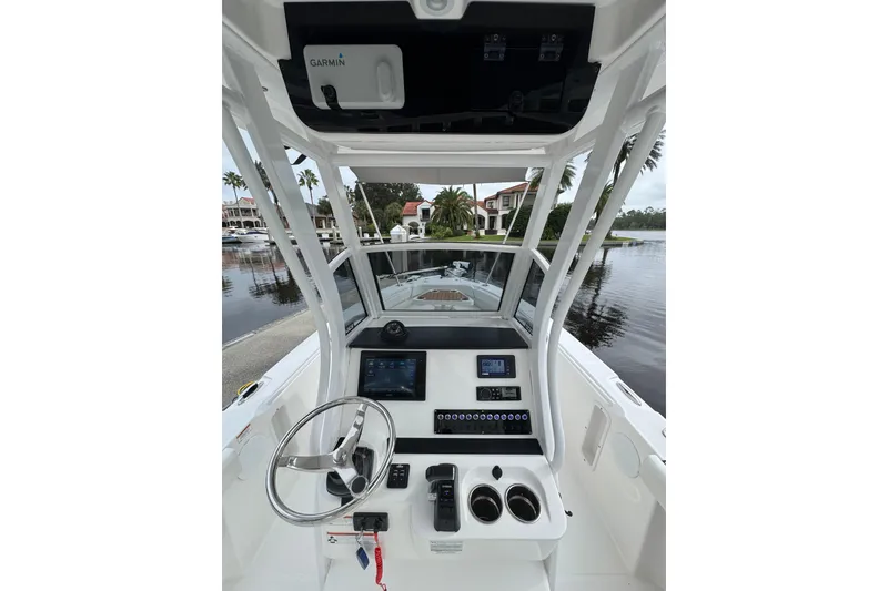 Slide: The Image of 2019 Edgewater 230CC boat cockpit with steering wheel and Garmin navigation system. - 2