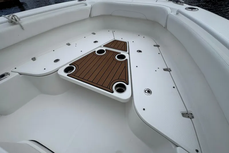 Slide: The Image of 2019 Edgewater 230CC boat interior with teak-style deck and cup holders. - 32