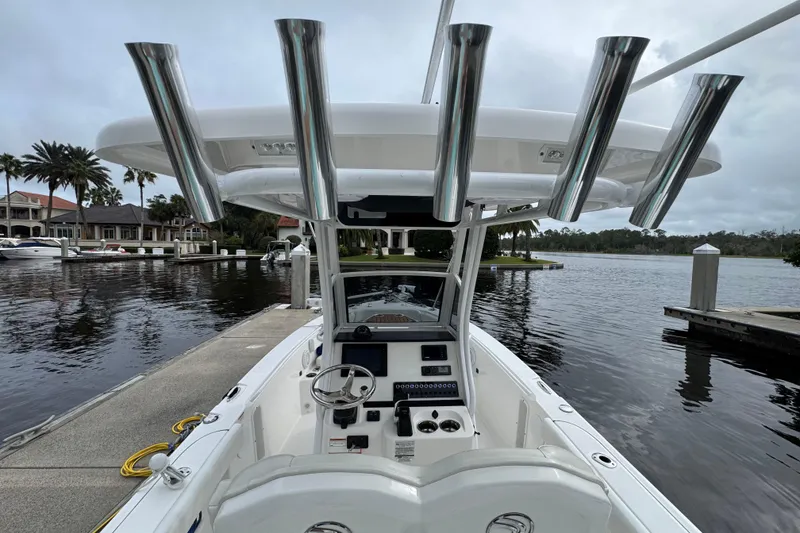 Slide: The Image of 2019 Edgewater 230CC boat docked by waterfront homes, featuring sleek design and modern controls. - 53