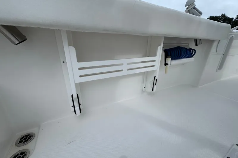 Slide: The Image of 2019 Edgewater 230CC boat interior with storage rack and coiled hose. - 56
