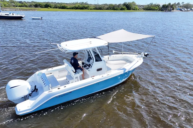 Slide: The Image of 2019 Edgewater 230CC boat cruising on a sunny day with canopy extended. - 6