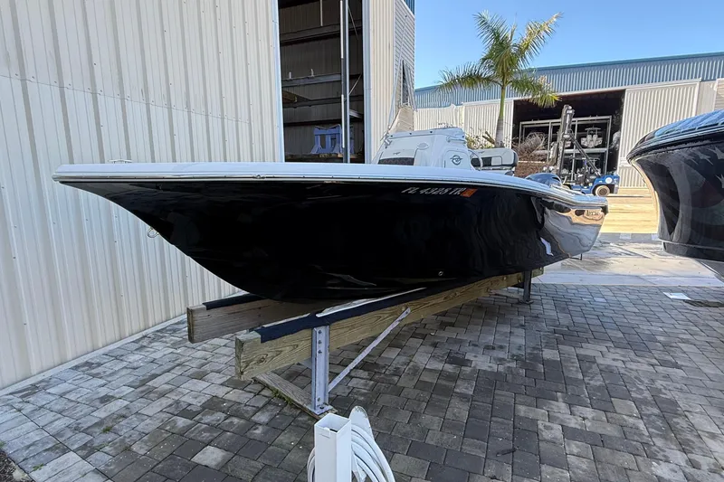 Slide: The Image of 2022 Tidewater 198 CC Adventure boat on display, black hull, outdoor setting. - 1