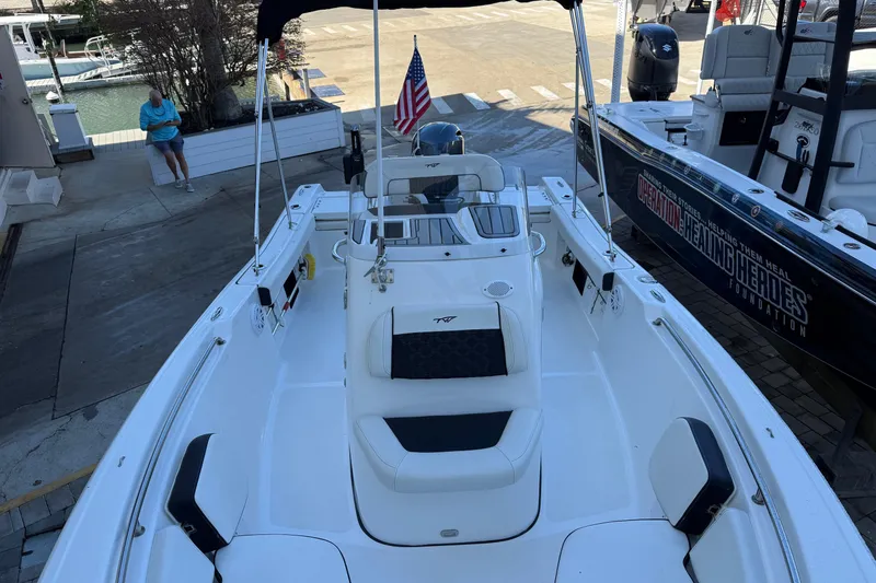 Slide: The Image of 2022 Tidewater 198 CC Adventure boat with seating and American flag, docked at marina. - 10