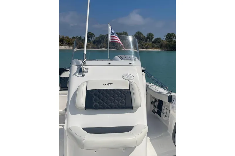 Slide: The Image of 2022 Tidewater 198 CC Adventure boat with American flag on calm water. - 16