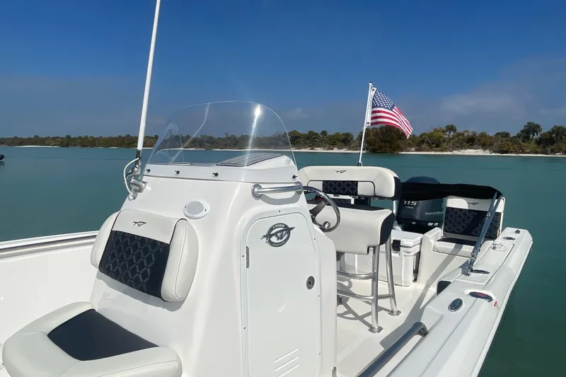 Slide: The Image of 2022 Tidewater 198 CC Adventure boat with American flag on calm water. - 3