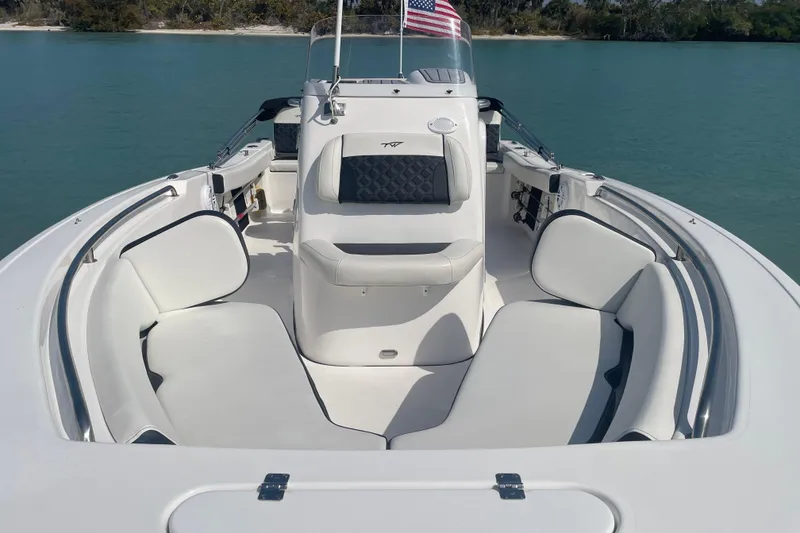 Slide: The Image of 2022 Tidewater 198 CC Adventure boat interior with cushioned seating and American flag. - 5