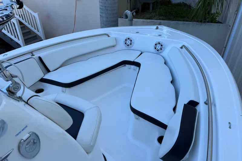 Slide: The Image of 2022 Tidewater 198 CC Adventure boat interior with white seating and speakers. - 8
