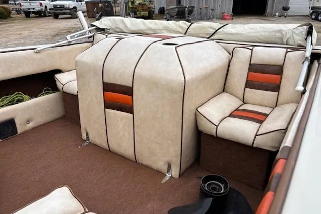 Slide: The Image of 1986 Galaxie Bowrider boat interior with beige and orange seating, outdoor setting. - 15