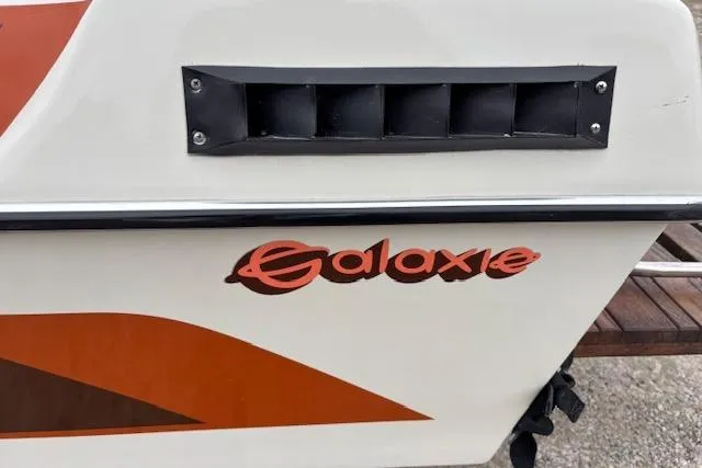 Slide: The Image of 1986 Galaxie Bowrider boat with distinctive orange logo and vent detail. - 17