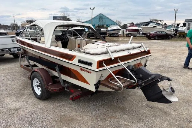 Slide: The Image of 1986 Galaxie Bowrider boat on trailer, parked outdoors, with white canopy and brown accents. - 3
