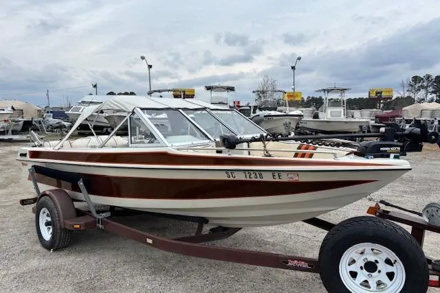 Slide: The Image of 1986 Galaxie Bowrider boat on trailer, parked in a marina with cloudy skies. - 7