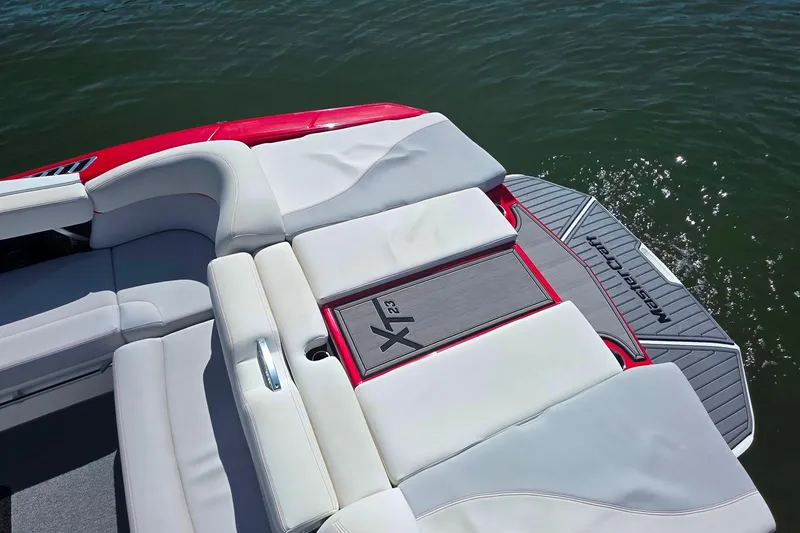 Slide: The Image of 2018 MasterCraft XT23 boat with sleek seating and swim platform on water. - 11