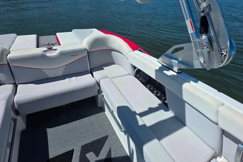Slide: The Image of 2018 MasterCraft XT23 boat interior with white seating and water backdrop. - 14