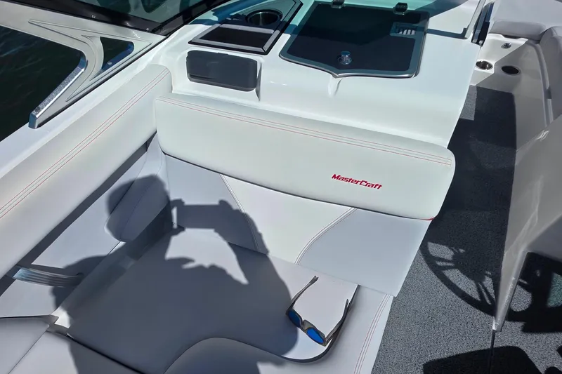 Slide: The Image of 2018 MasterCraft XT23 boat interior with white seating and sunglasses. - 18