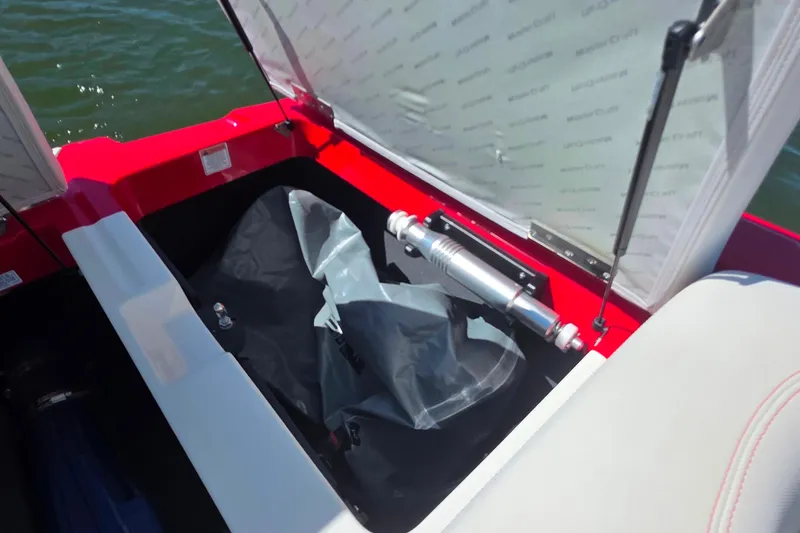 Slide: The Image of Open storage compartment in a 2018 MasterCraft XT23 boat, showing hydraulic lift and interior. - 21