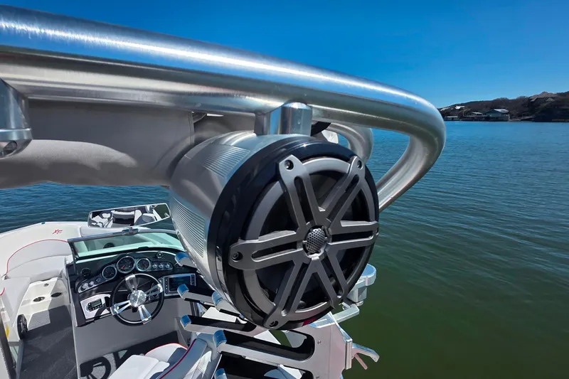 Slide: The Image of 2018 MasterCraft XT23 boat with speaker, steering wheel, and lake view. - 25