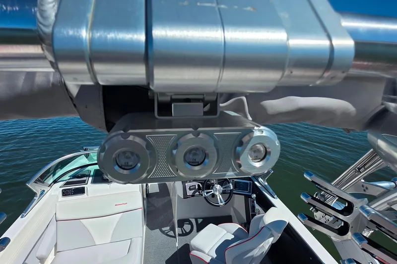 Slide: The Image of 2018 MasterCraft XT23 boat interior with steering wheel and seating, viewed from above. - 27