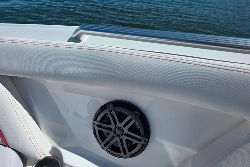 Slide: The Image of 2018 MasterCraft XT23 boat interior with speaker, white upholstery, and lake view. - 29